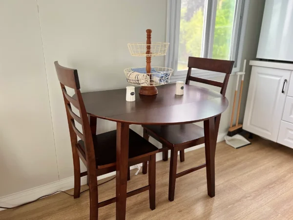 A small table with two chairs in front of a window.