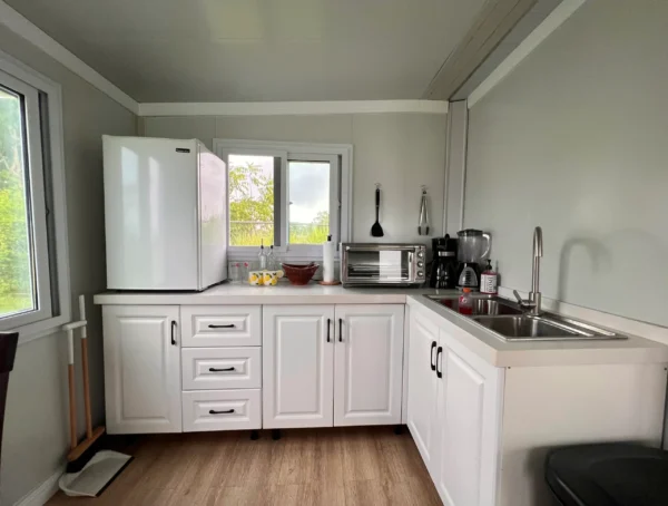 A kitchen with white cabinets and a refrigerator.