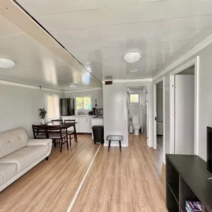 A living room with hard wood floors and white walls.