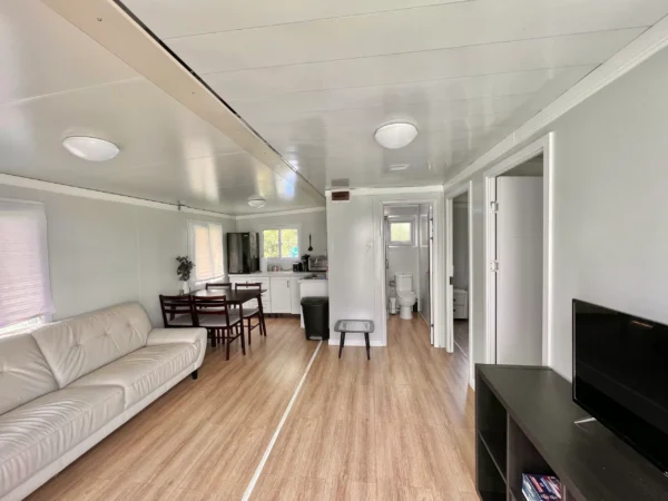 A living room with hard wood floors and white walls.