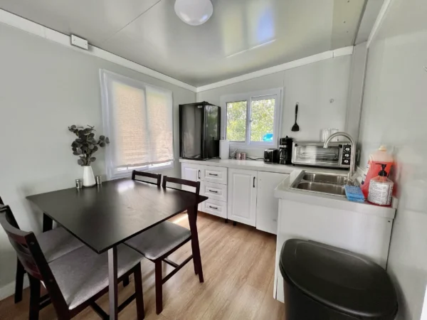 A kitchen with white walls and wooden floors.